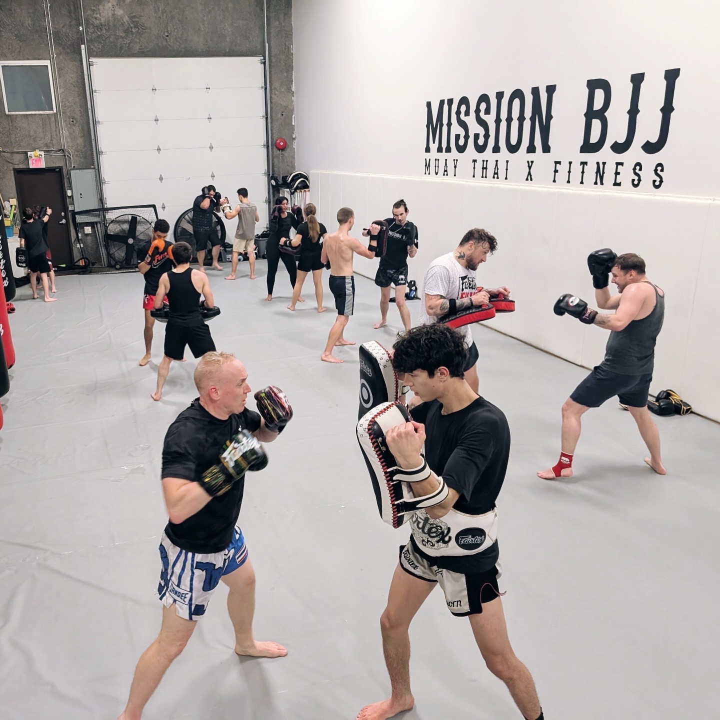 Members partnered up for pad work during a Muay Thai kickboxing class at Mission BJJ in Mission, BC